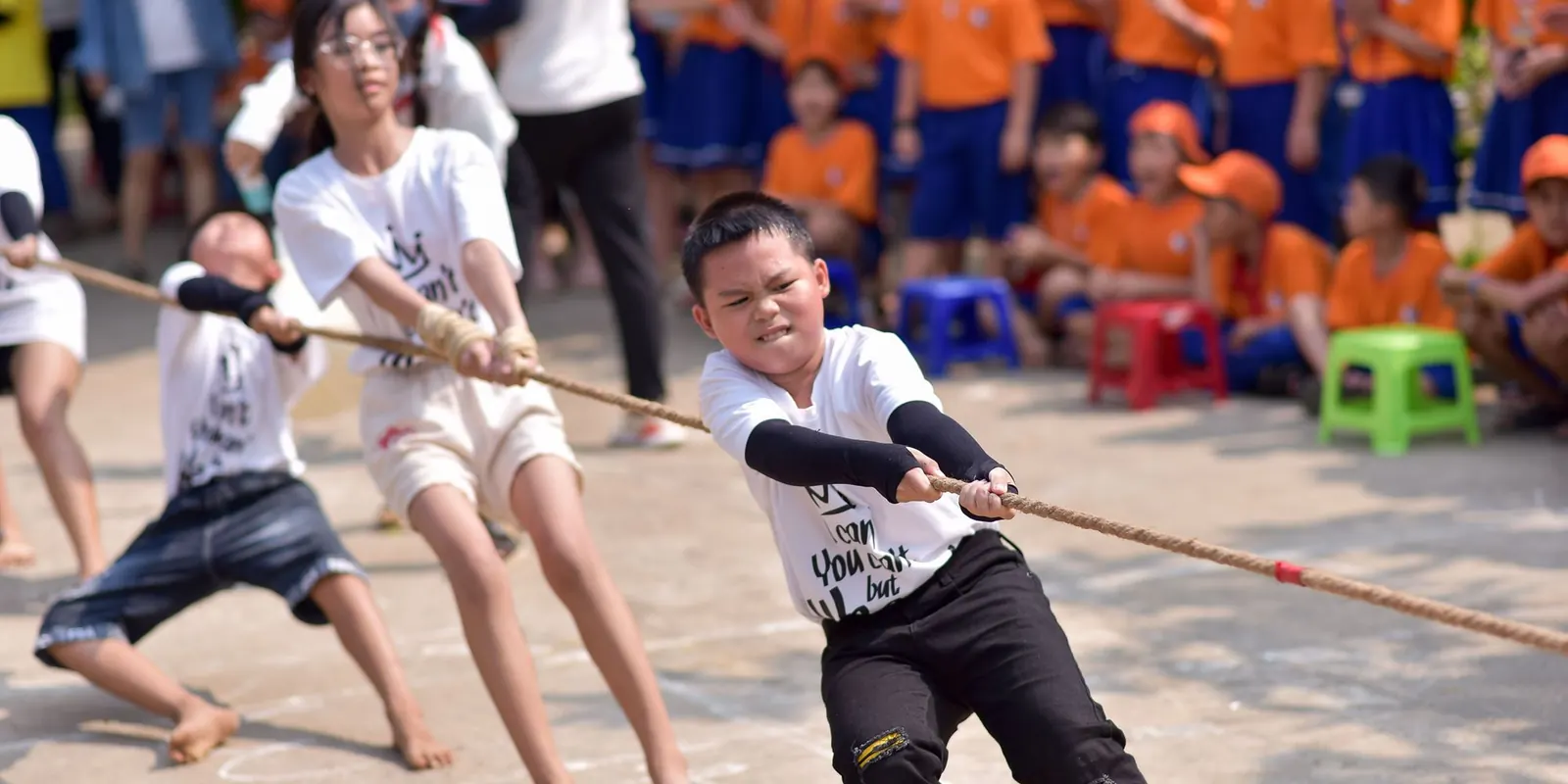 Students pulling hard in a tug-of-war during an inter-house sports day
