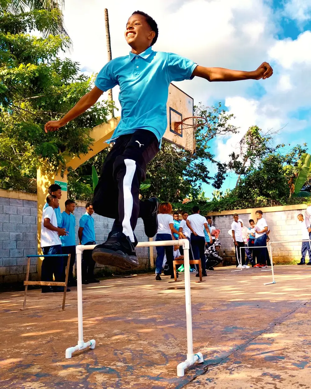 A pupil clearing a hurdle during athletics on the school ground